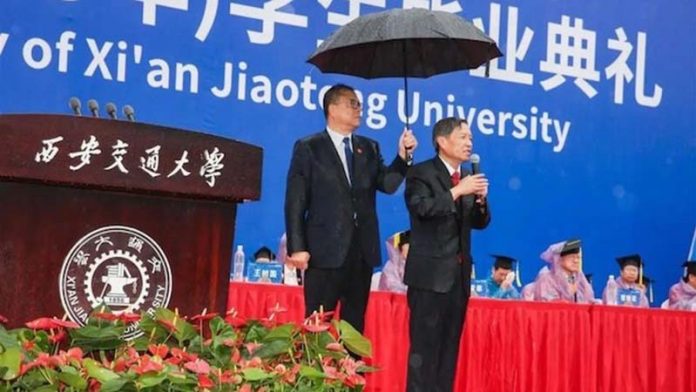 西安交大畢業典禮，校長王樹國在雨中致辭，書記盧建軍全程撐傘。圖／西安新聞網